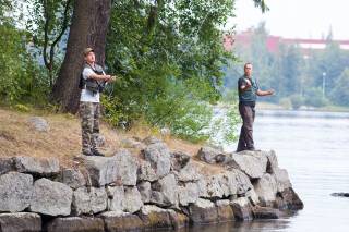 Men are fishing by the lake.