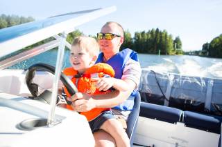 A man and a child driving a motor boat.