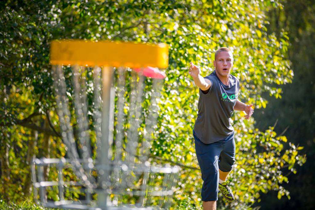 Miehet pelaavat frisbeegolfia.