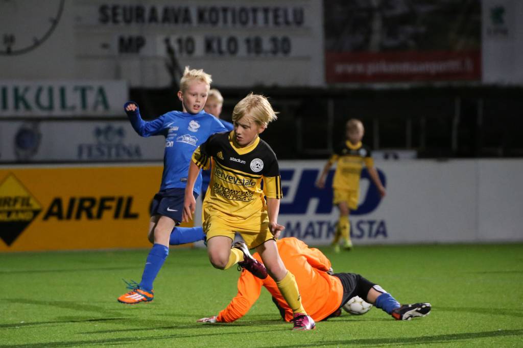 Pojat pelaavat jalkapalloa.