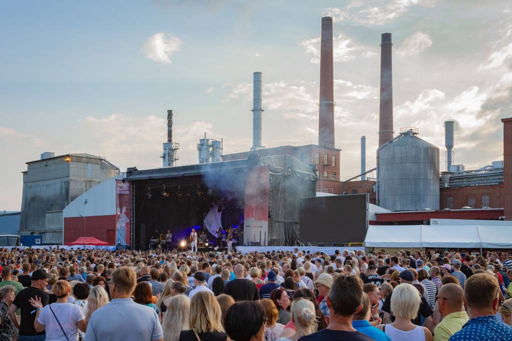 Esiintyjä lavalla yleisön edessä Työväen Musiikkitapahtumassa.