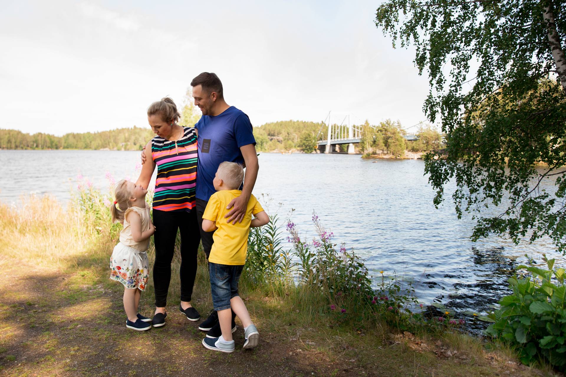 Perhe rannalla taustalla Sääksmäen silta