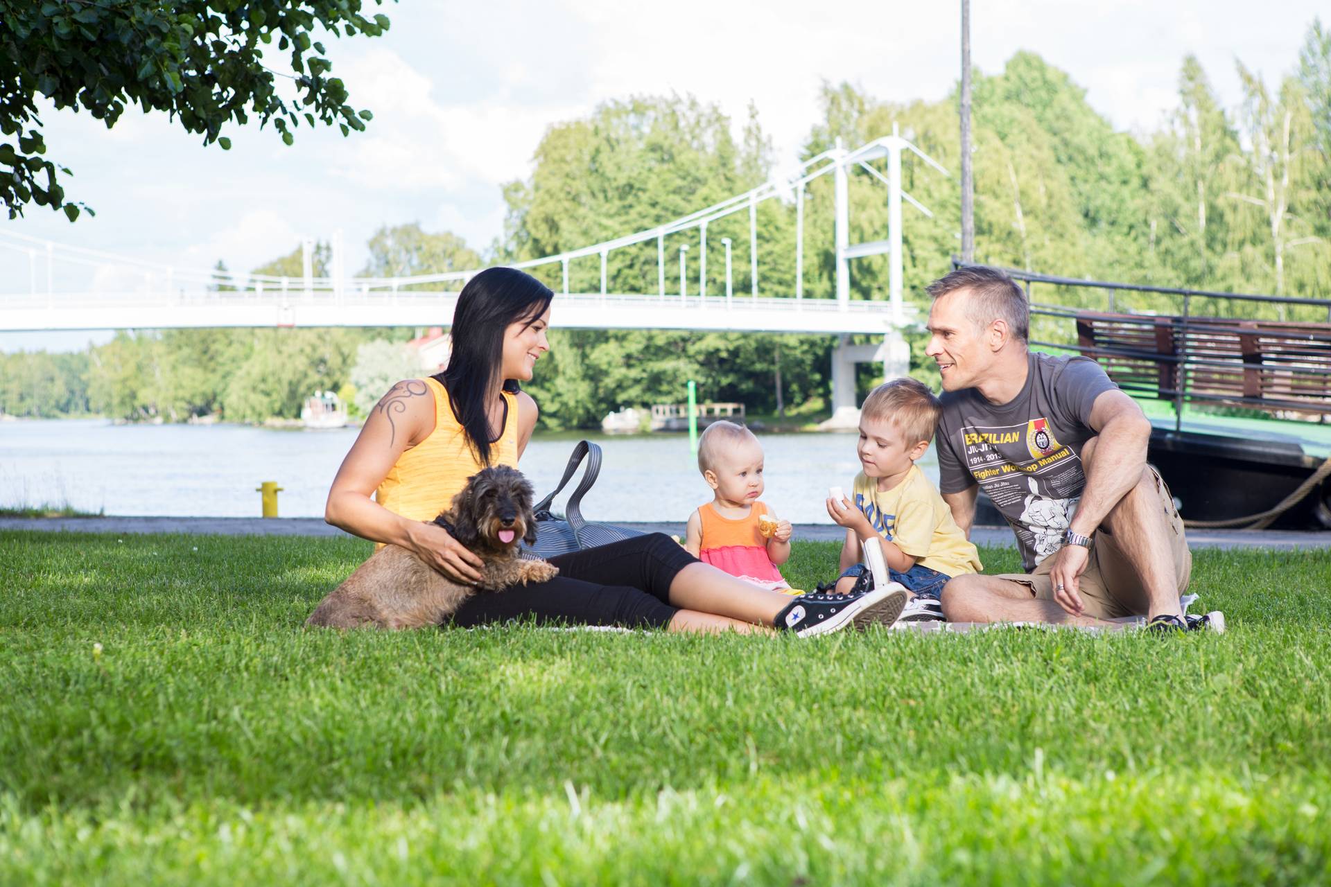 A family is sitting on the grass near Putaansilta