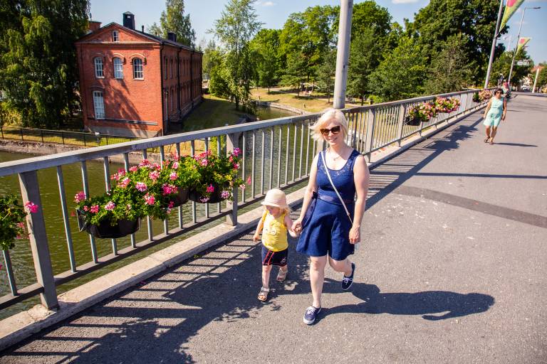 Nainen ja tyttö kävelee Valkeakosken keskustassa sillalla Myllysaaren edustalla
