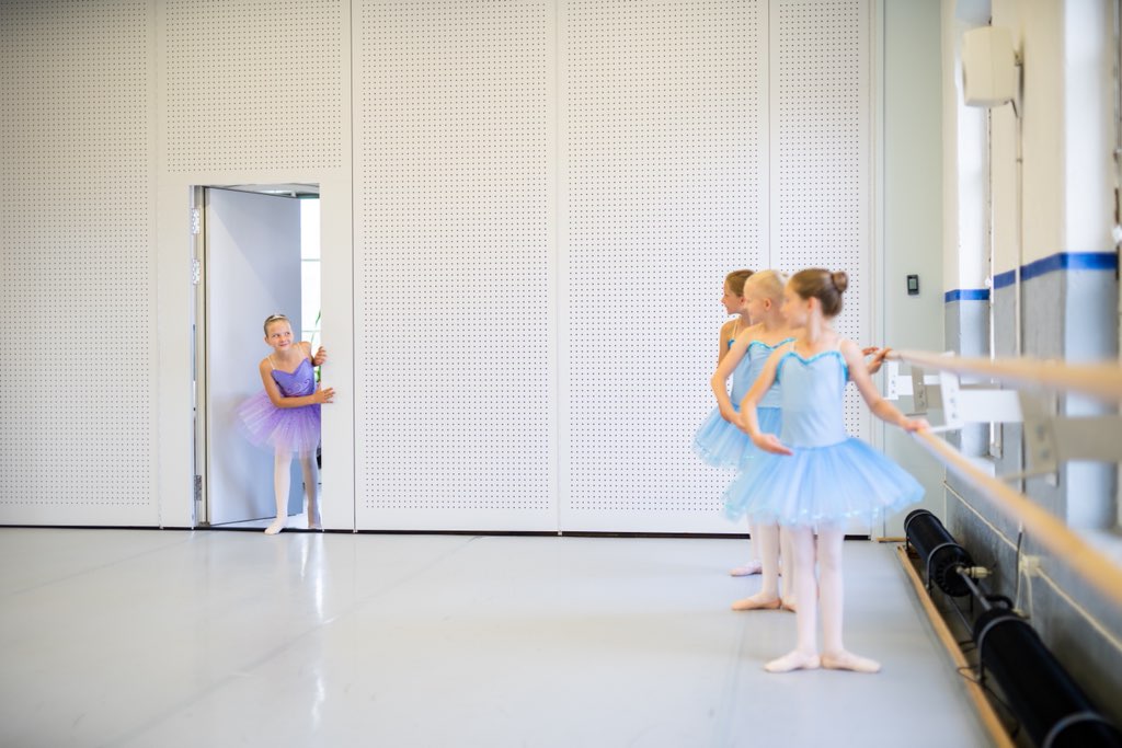 Balettioppilas astuu ovesta tanssisaliin