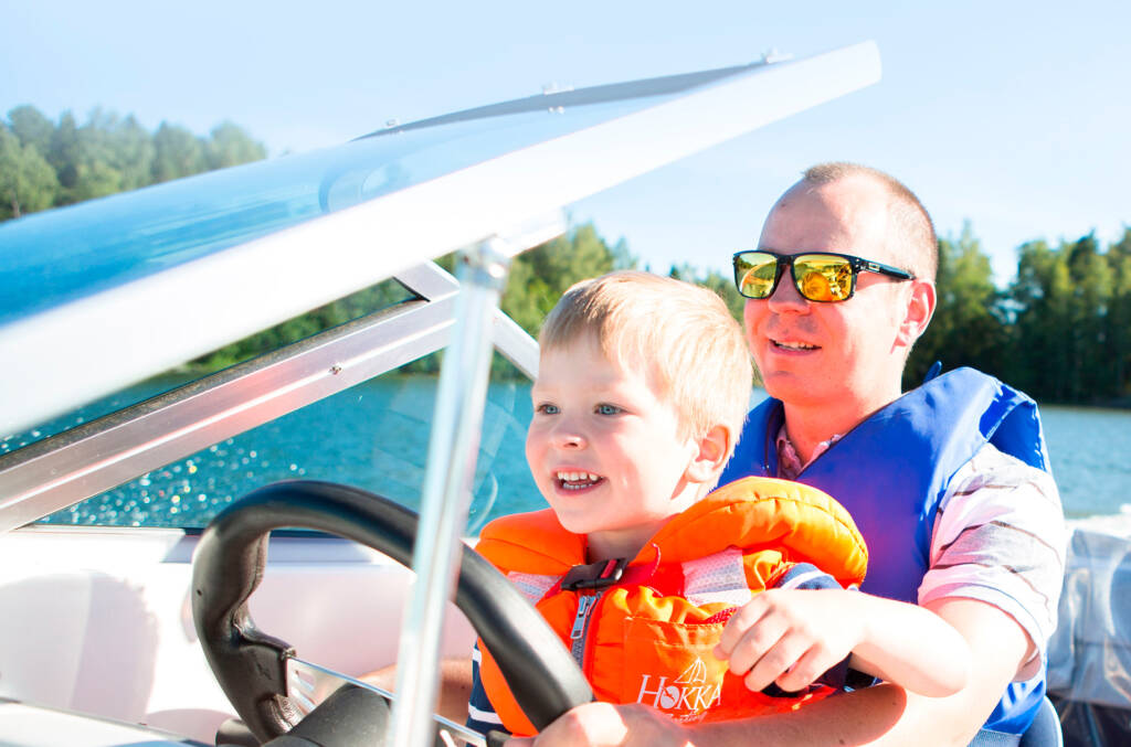 A man and a child driving a motor boat.