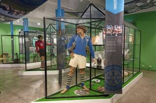Näyttelysali Suomen jalkapallomuseosta, jossa on mallinukkeja, joilla peliasut päällä.