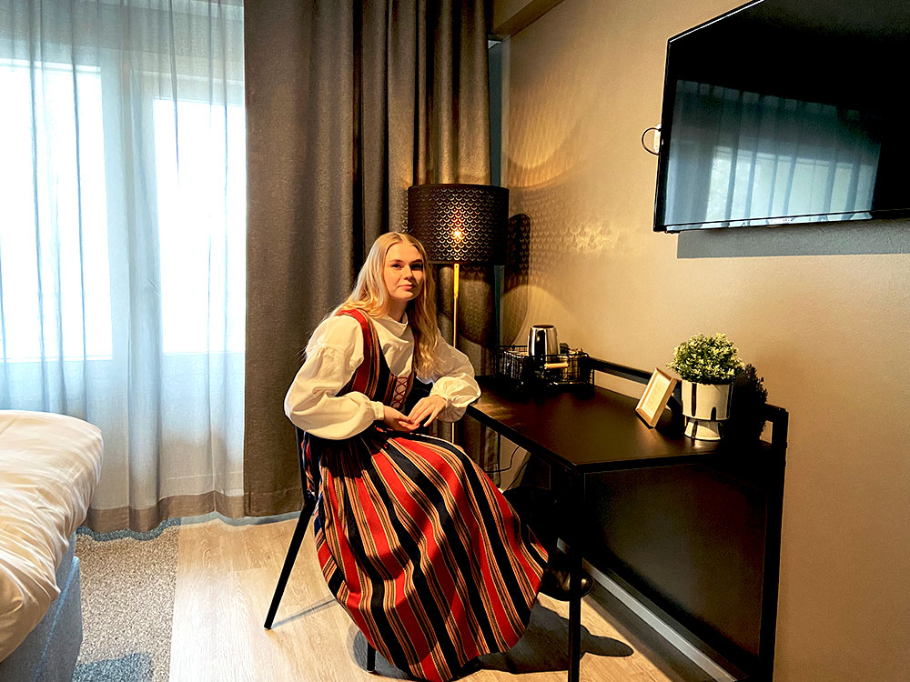 Nainen kansallispuku päällä Hotelli Waltikan uudistetussa hotellihuoneessa.