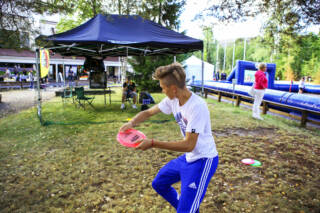 Poika heittää frisbeetä verkkoon Hotelli Waltikan pihassa.