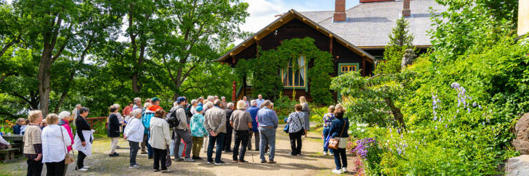 Ryhmämatkailijoita-ja-museo-opas-Visavuoren-museon-pihassa.