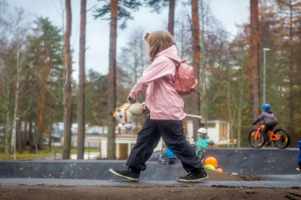 Lapsi kävelee keppihevosen kanssa.
