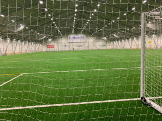 Näkymä palloiluhallin päädystä maaliverkon läpi.