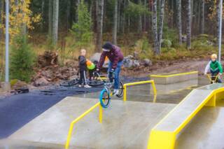 Poika tekee pyörätemppuja pumptrack-radalla.