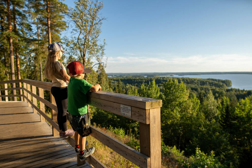 Lapset katsovat ilta-aurinkoa Rapolanharjun näköalatasanteelta.