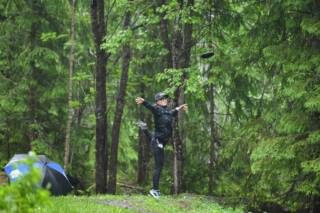 Nainen heittää frisbeegolfkisoissa Valkeakoskella.