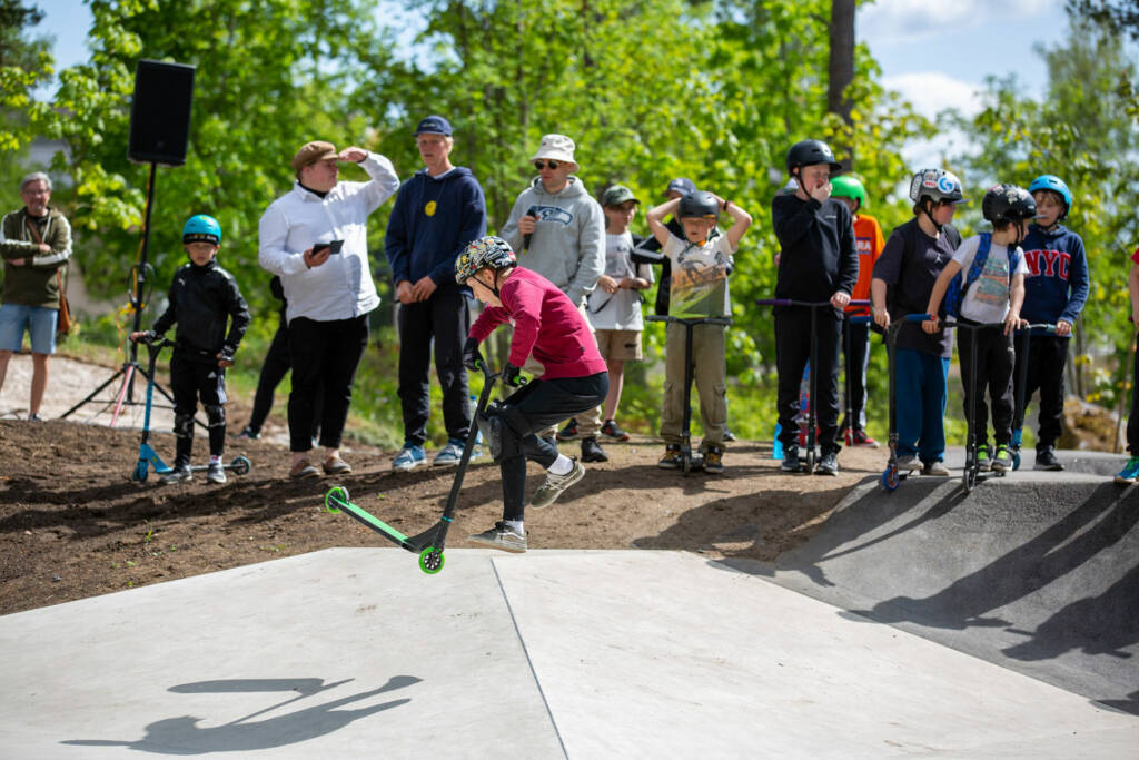 Henkilö tekee temppua potkulaudalla pumptrack-radalla.