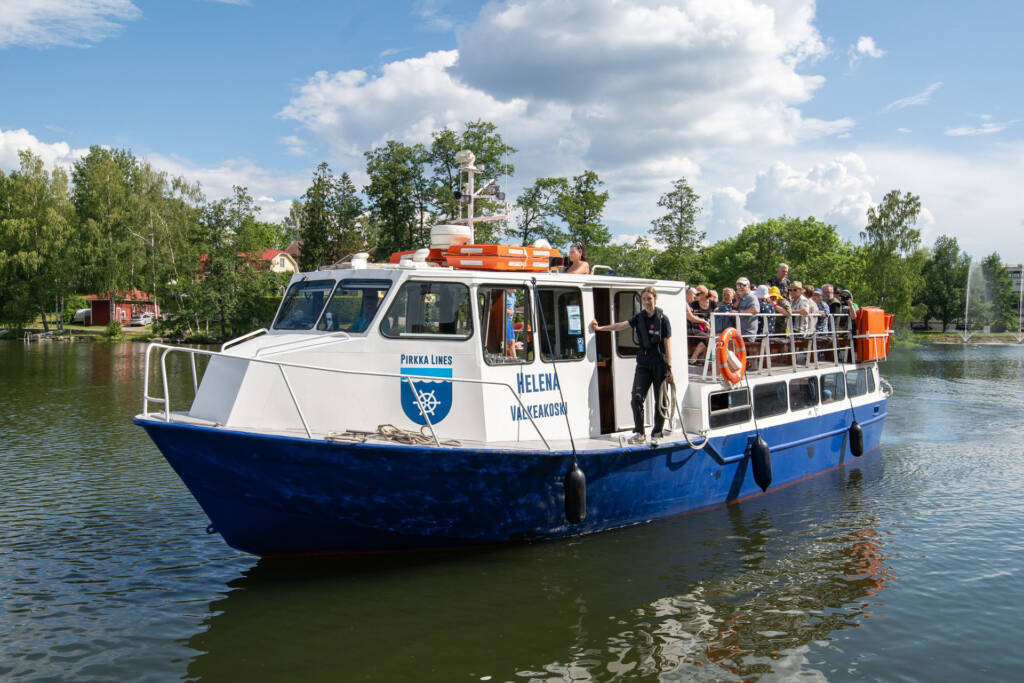 Sisävesiristeilylaiva M/S Helena vesillä ja ihmisiä istuu kannella.