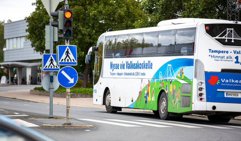 Nyssen linja-auto kääntymässä risteyksessä tielle.