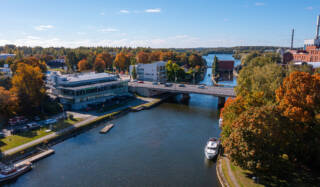 ilmakuva, jossa rakennuksia, silta ja järvi