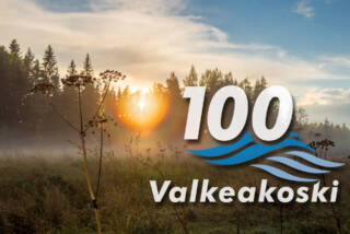 Syksyinen kuva auringonvalosta ja pellosta, Valkeakoski 100 -juhlalogo.