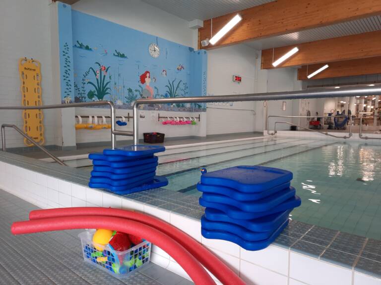 Uimaopetusvälineitä uima-altaan reunalla