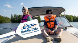 Lapset istuvat veneen kannella ja kuvassa teksti Vesistöviikko-tapahtuma Valkeakoskella 10.-16.6.2024.