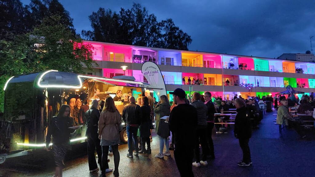 Ihmisiä Waltikan Venetsialaisissa ja värivaloin koristellut hotellihuoneet taustalla.