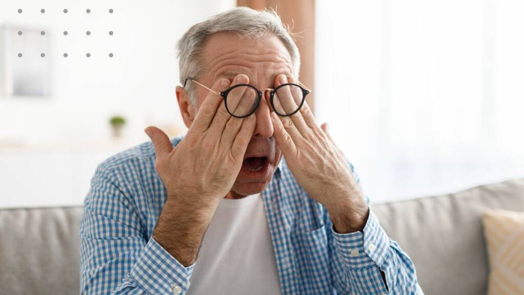seniori koskettaa silmiään silmälasien alta.