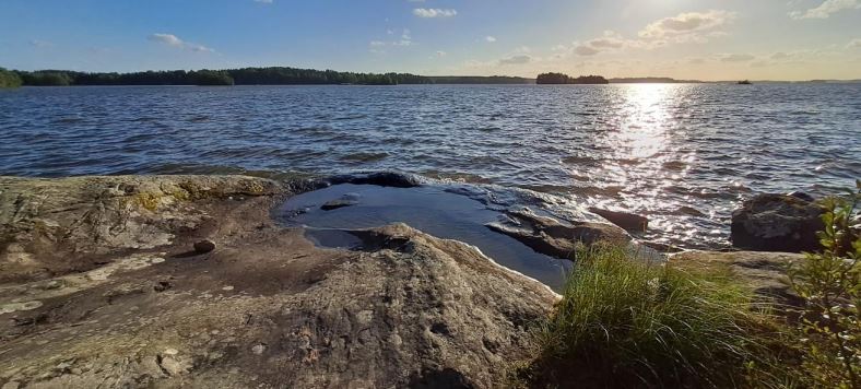 Kallio ja järvivesi vieressä.