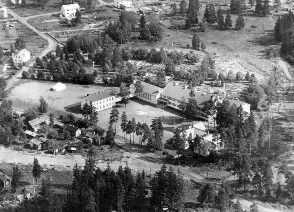Mustavalkoinen vanha ilmavalokuva Sorrilan koulun rakennuksista ja piha-alueesta.