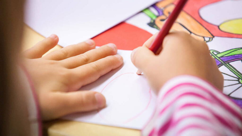 Lapsi piirtää paperille.