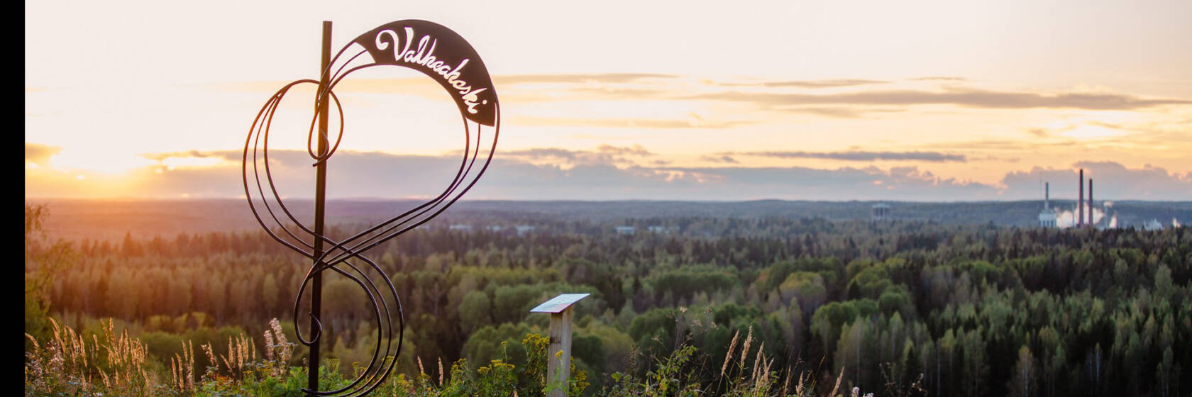 Maisemaseinä auringonlaskua vasten.