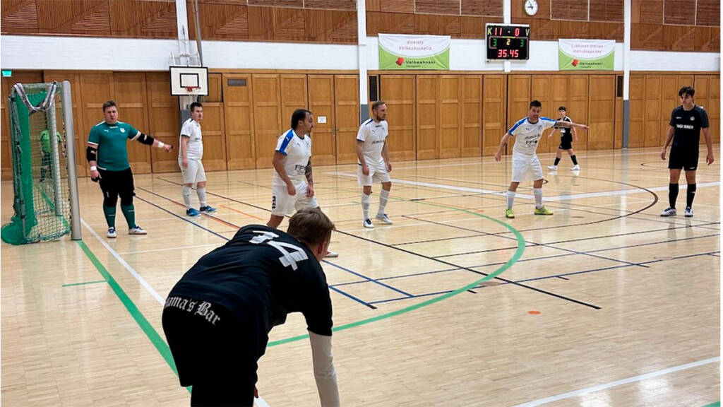 Miehet pelaavat futsalia liikuntahallissa.