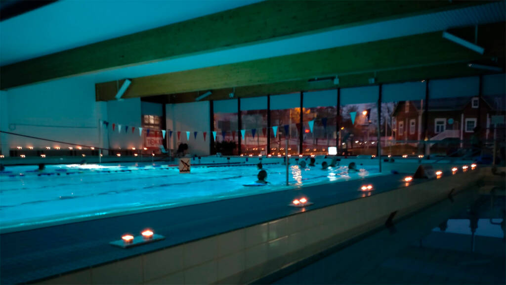 Uimahallin allasalue valaistuna kynttilöin.