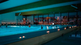 Uimahallin allasalue valaistuna kynttilöin.