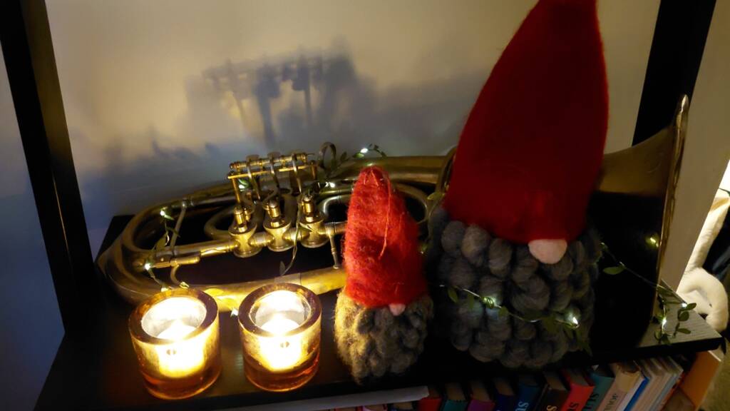 Puhallin, kynttilöitä ja pari joulutonttua.