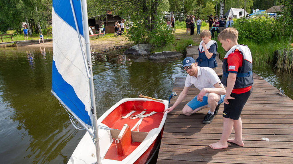 Lapsia lähdössä purjentimaan pienellä veneellä.