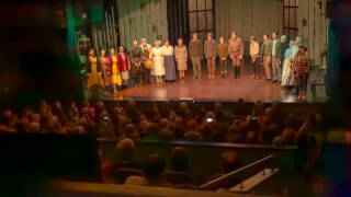 Yleisöä ja näyttelijöitä kaupunginteatterin näyttämöllä.