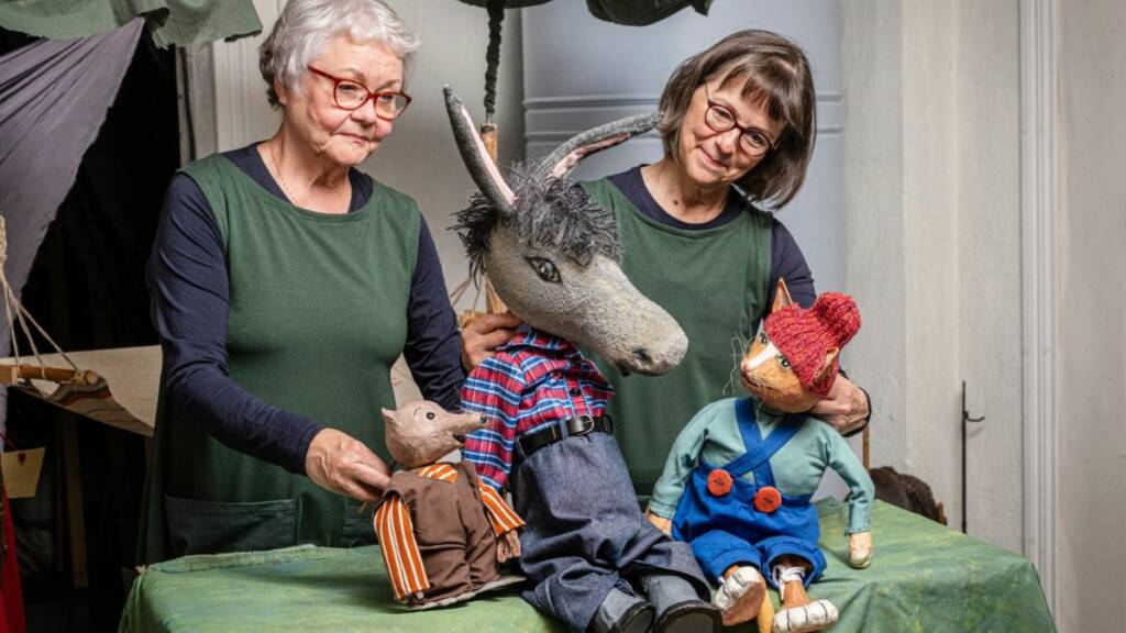 Nukketeatteriesitys, nuket aasi ja kettu ja kaksi esiintyjää.