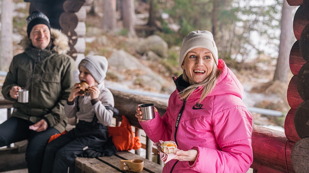 Nainen ja lapsi istuvat nuotiopaikalla.