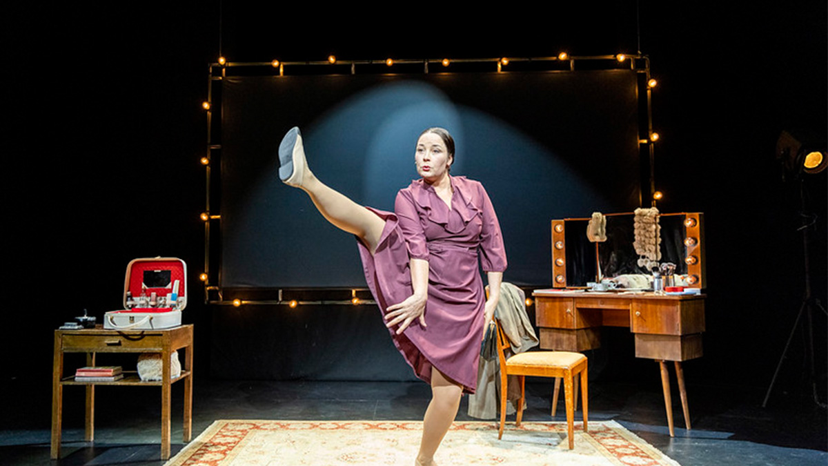 Tanssiva nainen teatteri esityksessä.