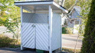 Etualalla vaalea jätekatos ja takana näkyy tie.