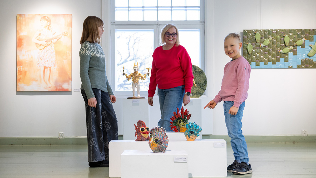 Ihmisiä katselemassa taidenäyttelyä Voipaalan taidekeskuksessa.