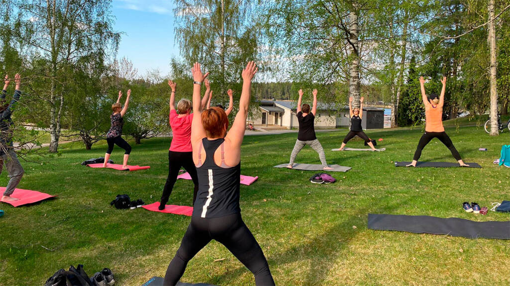 Ihmisiä jumppaamassa nurmialueella.