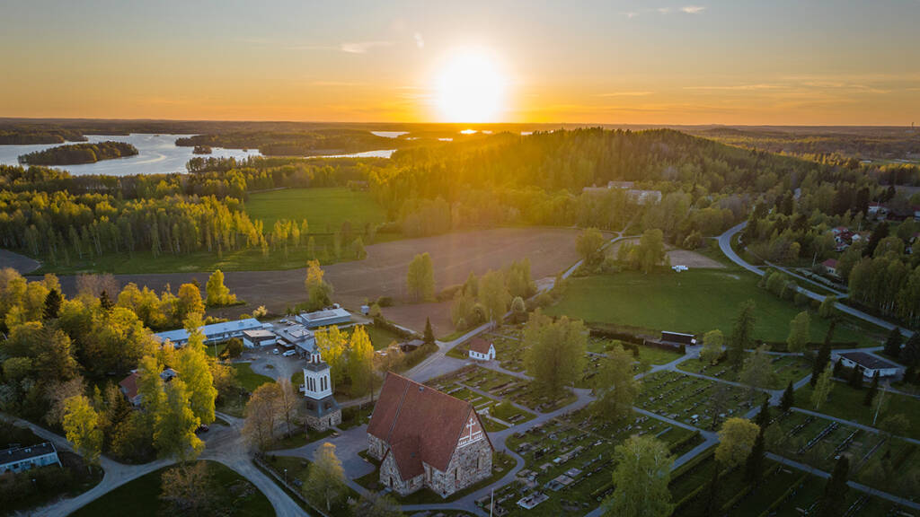 Ilmakuva Sääksmäen kirkon alueelta auringonlaskun aikaan.