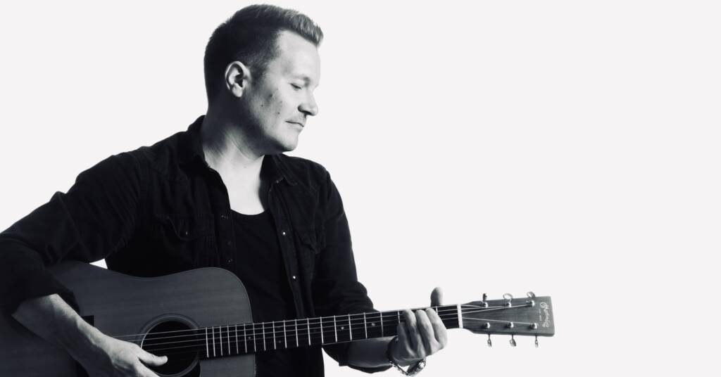 Laulaja-lauluntekijä Mika Rämä soittaa kitaraa.