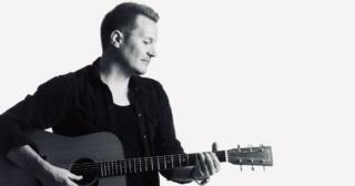 Laulaja-lauluntekijä Mika Rämä soittaa kitaraa.