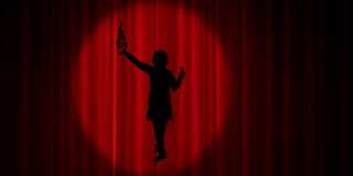 Punaisen näyttämöverhon takana seisoo hahmo.