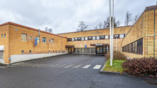 Valkeakosken terveyskeskuksen pääovi kuvattuna ulkopuolelta.