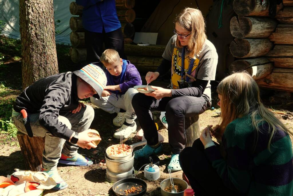 Retkeilijöitä laavulla laittamassa ruokaa.
